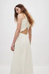 Vestido midi blanco de popelina de algodón, con cuerpo fruncido tipo nido de abeja, escote cuadrado y tirantes anchos con volantes que se cruzan en la espalda. Falda con ligero vuelo.