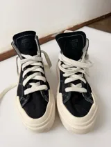 Championes Converse Chuck Taylor All Star Cruise Hi de lona negra, caña alta con plataforma y suela de goma blanca. Costuras en contraste y puntera reforzada.