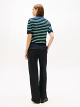 Chomba de piqué de Tommy Hilfiger en mezcla de algodón elástico, color azul marino con rayas horizontales en verde y blanco. Cuenta con cuello polo, media cremallera frontal y logo bordado en el pecho.