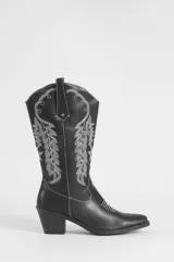 Bota texana negra de cuero vegano con detalles de costuras y bordados en hilo blanco en la caña y la puntera. Cuenta con taco bloque y tiradores laterales.