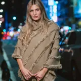 Poncho color habano con cuello alto y flecos diagonales. Tejido de acrílico.