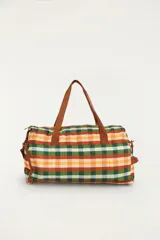 Bolso de viaje tipo duffel multicolor con estampado de cuadros vichy en tonos verde, rojo, amarillo y celeste. Cuenta con asas de mano y correa de hombro ajustable marrón, con detalles de la marca y bolsillos con cierre.