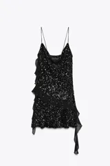 Vestido corto de escote fluido y tirantes finos, completamente cubierto de lentejuelas negras. Presenta detalles de volantes en tejido combinado que recorren el lateral y el frente de la prenda.
