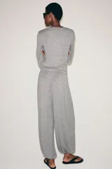 Pantalón bombacho confeccionado en mezcla de lyocell, color gris melange. Presenta tiro medio, cintura elástica con cordón de ajuste, pierna ancha y bajo abullonado con elástico.
