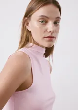 Top entallado color rosado, con cuello perkins y diseño sin mangas.