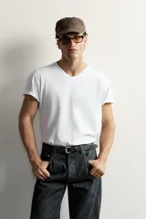 Camiseta blanca de corte relajado, con cuello en V y mangas cortas.