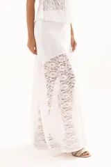 Pollera larga de encaje blanco con diseño de capas y transparencia, de corte fluido y estilo romántico.