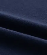 Blusa azul marino de crepé, con escote en V y mangas cortas. Presenta detalles de punto en el cuello y los puños de las mangas, así como flecos en los laterales de los puños.