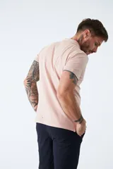 Chomba manga corta color rosa pálido, de corte regular, con cuello clásico con botones, logo bordado en el pecho y terminaciones con ribete en contraste. Confeccionada en algodón y spandex.