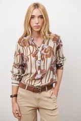Camisa de manga larga con estampado floral en tonos marrones y negros, cuello mao y cierre frontal parcial con botones.