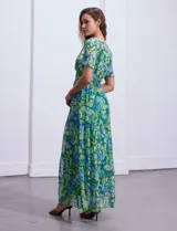 Vestido largo de gasa estampada con flores en tonos verde y azul, escote en V delantero y trasero, corte en la cintura con punto smock y mangas cortas.