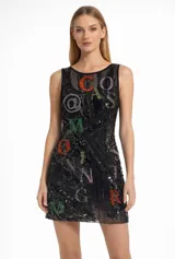 Vestido corto negro sin mangas, con escote redondo y diseño completamente bordado con lentejuelas y apliques de pedrería multicolor que forman letras y símbolos.
