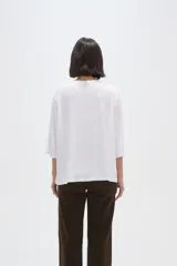 Remera de viscosa en color verde oliva, con cuello redondo y mangas 3/4. Presenta un diseño de tejido acanalado y corte holgado.