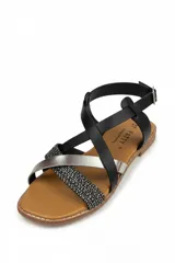 Sandalia plana Bettina modelo BT308, con tiras cruzadas en la parte delantera y cierre ajustable en el talón. Presenta una combinación de tiras en color blanco, plateado y detalles texturizados con brillos.