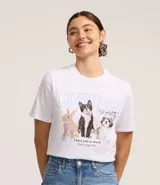 Remera de algodón blanca, modelo t-shirt, con cuello redondo y manga corta. Presenta un estampado frontal con la palabra "CUTIES" y dibujos de un conejo, un gato y un perro, junto con texto motivacional.