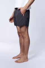 Short de baño estilo runner, color negro liso, con corte por encima de la rodilla y cintura elástica.