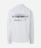 Camisa de manga larga con diseño de rayas verticales, cuello clásico y cierre frontal con botones. Confeccionada en una mezcla de algodón, poliamida y elastano, presenta una estampa gráfica en la espalda con la frase Echoes of a Restless Beat.