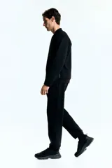 Campera bomber deportiva negra, confeccionada en tejido funcional DryMove™ que absorbe el sudor. Presenta cuello elevado corto, cierre bidireccional, mangas raglán y bolsillos delanteros con cierre y costuras selladas. Posee elástico fino en puños y bajo.