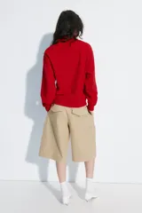 Bermuda larga cargo de color beige, confeccionada en mezcla de algodón. Cuenta con tiro medio, cintura con trabillas, pinzas en el delantero y bolsillos estilo cargo en las piernas.