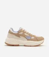 Championes de estilo urbano y deportivo de la marca Satinato, modelo jogging, confeccionados en poliuretano y poliéster en tonos beige, tostado y lila. Presentan una suela robusta texturizada y detalles en malla respirable.