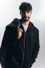Campera deportiva negra con cierre frontal y capucha con cordones ajustables.