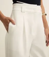 Pantalón pantalona de corte sastrero color blanco, con trabillas en la cintura y pliegues delanteros.