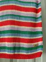 Musculosa de hilo confeccionada en tejido de punto, con diseño a rayas horizontales multicolor en tonos rojo, celeste, lila, verde y amarillo.