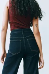 Pantalón de jean tiro alto, color azul oscuro, de corte ancho y pierna recta. Presenta costuras en hilo contrastante y grandes bolsillos parche delanteros y traseros.