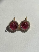 Aros colgantes dorados con dije circular de resina color turquesa, bordeado con strass. El arito es de acero quirúrgico.
