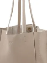 Cartera tipo tote bag color beige claro, con textura granulada y asas dobles.