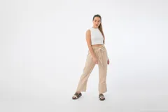 Pantalón de tela color beige, con cintura alta elastizada y cordón ajustable.