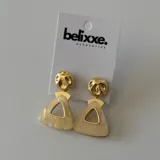 Par de aros colgantes con base redonda dorada y dije triangular con abertura, en color verde y beige.