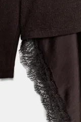 Vestido de punto con cuello redondo y manga larga, que presenta un bajo asimétrico de satén con detalle de encaje a tono.
