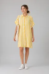 Vestido camisero de corte holgado y silueta relajada, con cuello clásico, cierre frontal de botones y mangas cortas con dobladillo. Presenta un estampado de cuadros irregulares en color bordó sobre fondo blanco.