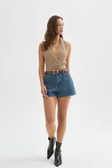 Top de punto con lentejuelas en tonos beige y dorado, con escote halter cruzado en V, sin mangas y corte corto.