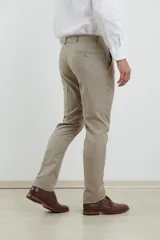 Pantalón de vestir azul marino, de corte recto, con bolsillos laterales y traseros. Se ajusta a la cintura con cinturón de cuero negro.