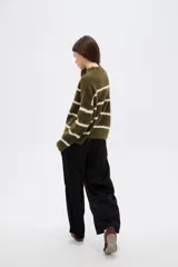 Sweater de punto con diseño de rayas horizontales en contraste, cuello alto y corte holgado con mangas largas.