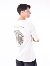 Remera negra de corte oversize con cuello redondo y manga corta. Presenta un pequeño estampado en el pecho con texto en color verde azulado.