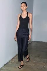 Top de cuello halter con diseño ajustado y escote con costuras tipo corset en el busto. Presenta espalda descubierta y bajo recto.