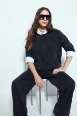 Buzo negro con efecto lavado y costuras verticales a la vista, de calce relajado.