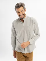Camisa de corte regular confeccionada en tejido oxford, color azul claro. Presenta cuello con botones, cierre frontal abotonado, mangas largas con puños y un bolsillo frontal en el pecho.