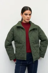 Campera corta color marrón con diseño capitoneado de rombos, cuello alto y bolsillos frontales grandes.