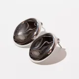 Par de aros tipo caravana ovalados, de acero color plateado con diseño marmolado en negro y blanco.