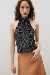 Top halter de cuello alto, confeccionado en tejido negro con acabado brillante y textura sutil.