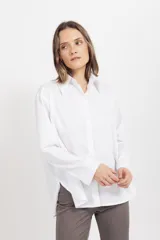 Camisa de corte clásico y silueta holgada, confeccionada en algodón con un toque de spandex. Presenta cuello camisero, cierre frontal con botones y mangas largas con puños abotonados.