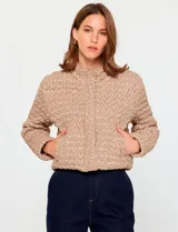 Campera Current Air de textura capitoneada irregular, color beige. Presenta cuello alto, cierre frontal oculto, bolsillos laterales y mangas largas con corte recto y levemente corto.