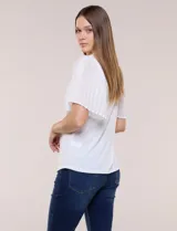 Blusa blanca con escote redondo y mangas cortas estilo mariposa confeccionadas en tela plisada translúcida.
