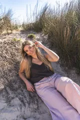 Pantalón palazzo color lila de lino, con cintura elastizada y bolsillos laterales desflecados.