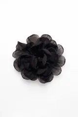Broche en forma de flor realizado en tela semitransparente con múltiples capas de pétalos.