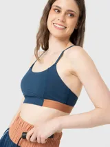 Top deportivo azul denim de sujeción media y corte ajustado, con tirantes finos y detalle bicolor en la banda inferior. Confeccionado con tecnología Aloe Vera.